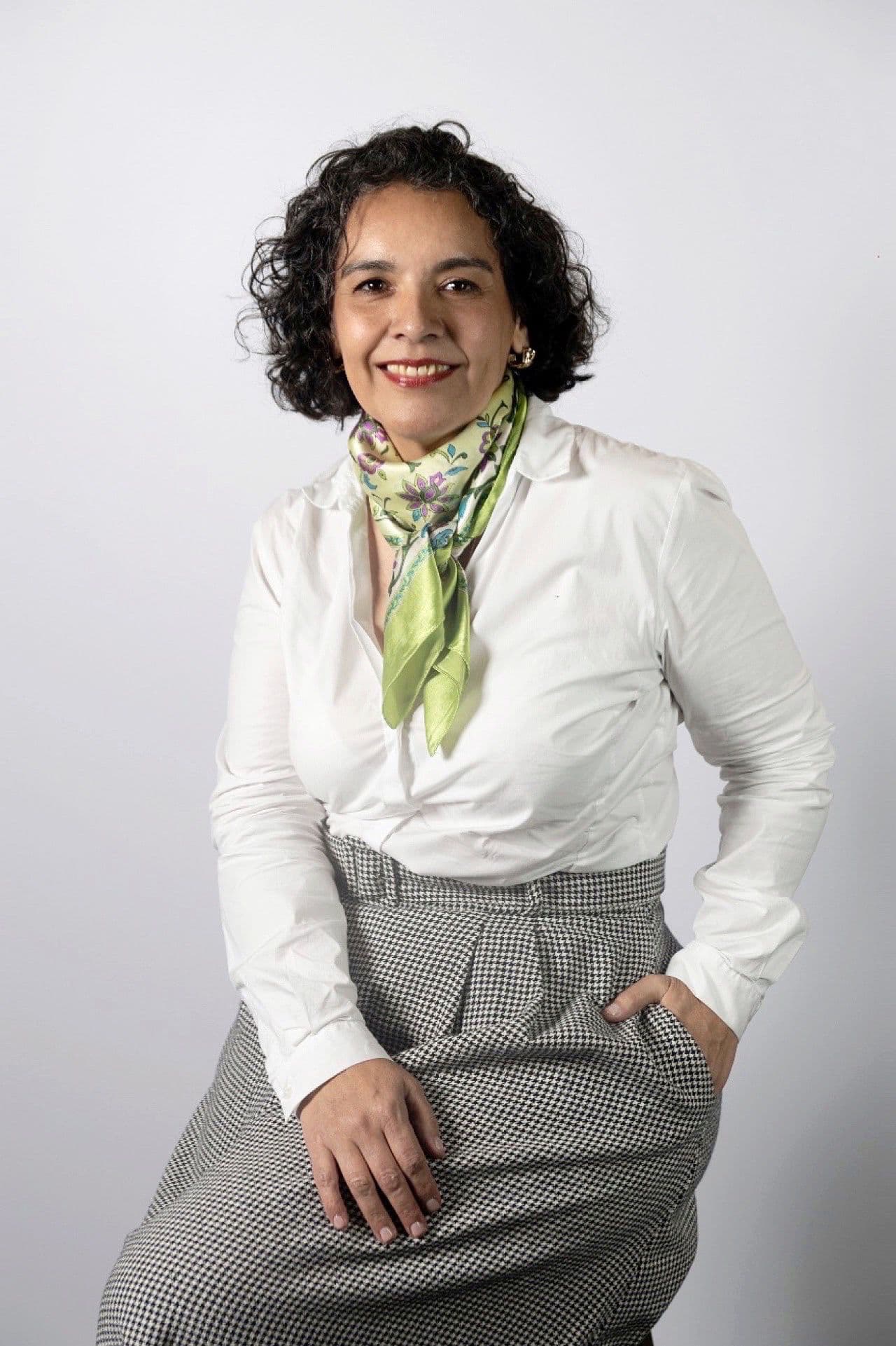 Portrait of Gabriela Capalbo, founder and mentor, smiling in front of a white background.